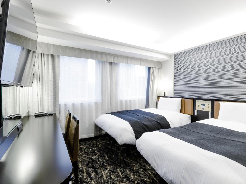 Postel nebo postele na pokoji v ubytování APA Hotel & Resort Roppongi Ekihigashi