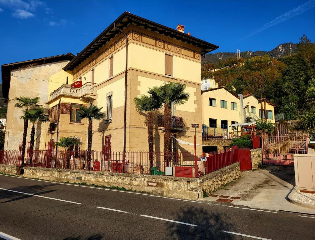 a building with palm trees in front of a street at Bed & Breakfast Villa Palma in Lovere