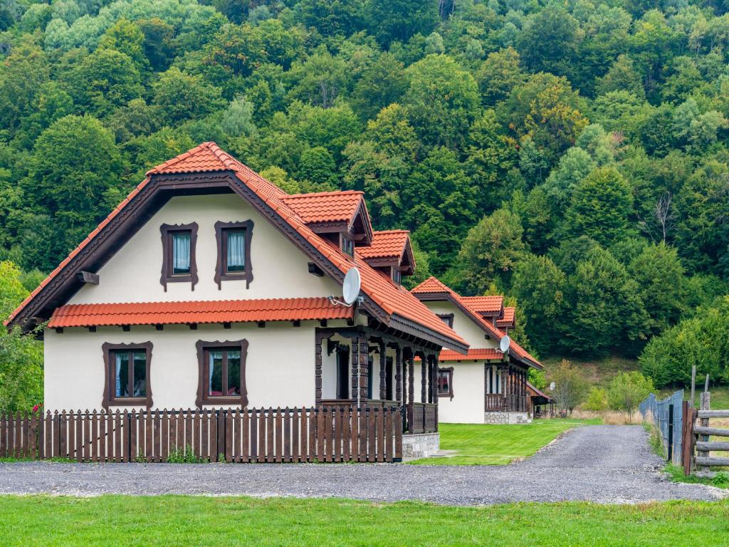 une maison avec une clôture en face d'une montagne dans l'établissement King’s Rock Guesthouse, à Zărneşti