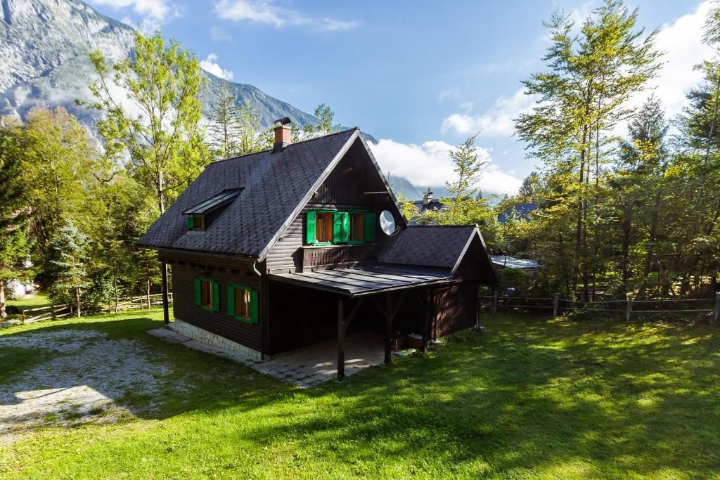 a small house sitting on top of a lush green field at Holiday home Pri Metki - Bohinj in Bohinj