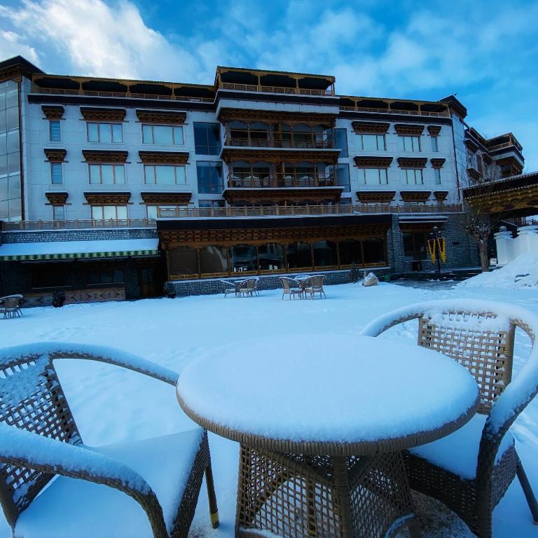 a table and chairs in the snow in front of a hotel at The Grand Dragon Ladakh in Leh