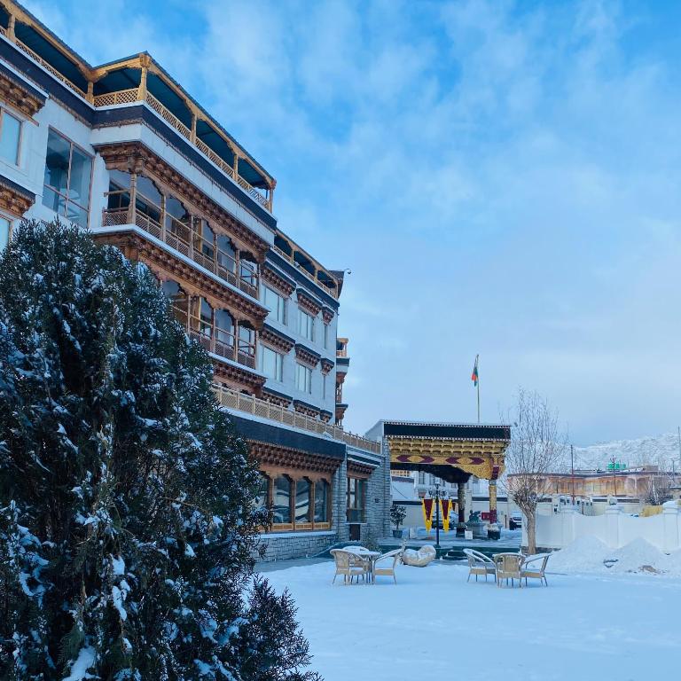 a building with benches in the snow in front of it at The Grand Dragon Ladakh in Leh