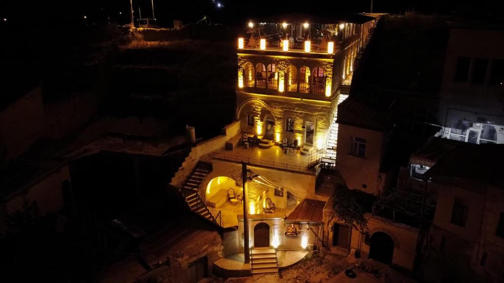 a building lit up at night with lights on it at Dionysos Cave Cappadocia Hotel in Urgup