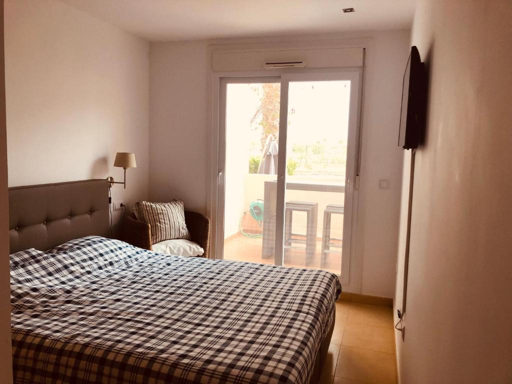 a bedroom with a bed and a sliding glass door at La Mariposa in Alhama de Murcia