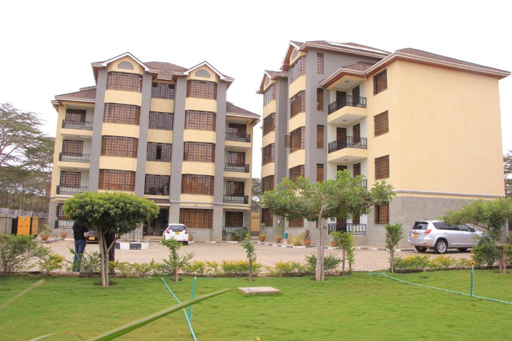 zwei große Apartmentgebäude mit einem Park davor in der Unterkunft BIDA FURNISHED APARTMENTS in Naivasha