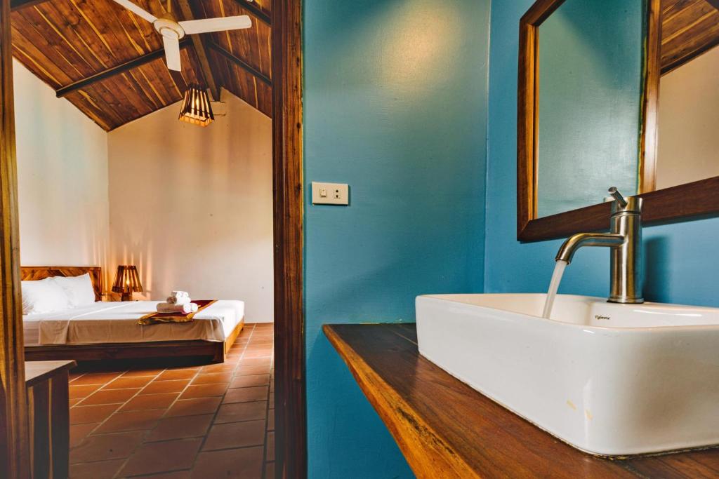 a bathroom with a sink and a bedroom with a bed at Star Hill Village Resort Phu Quoc in Phú Quốc