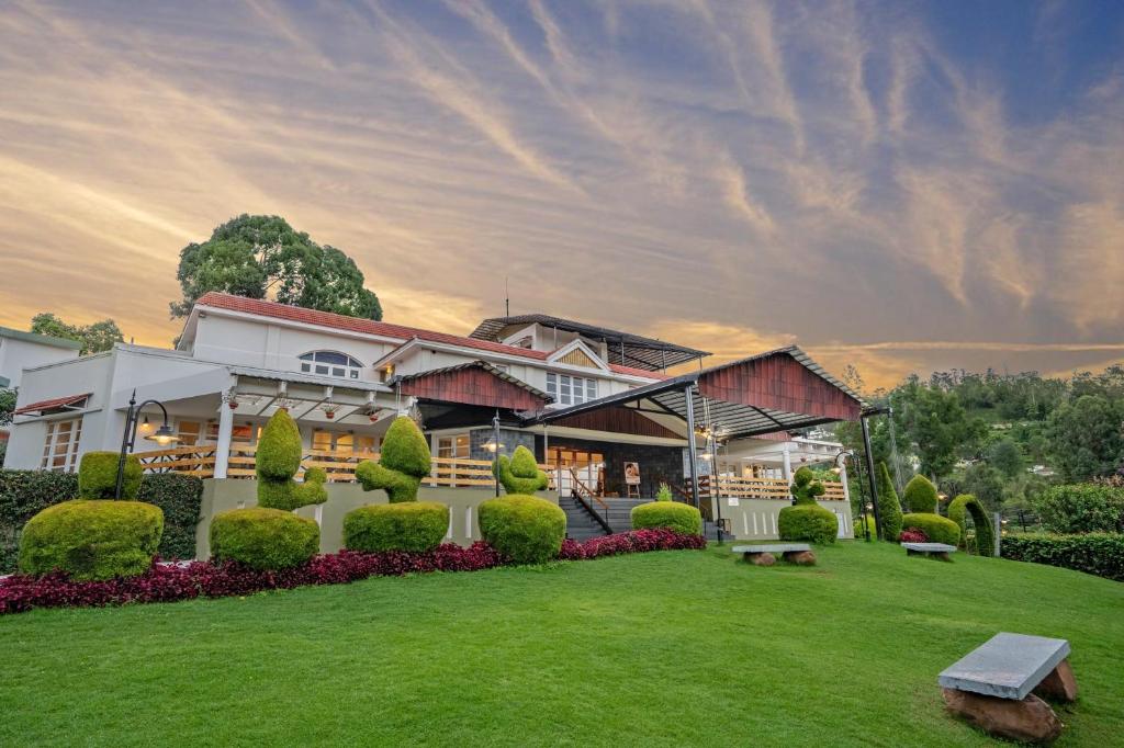 a house with a green lawn in front of it at Sterling Kodai Lake in Kodaikānāl