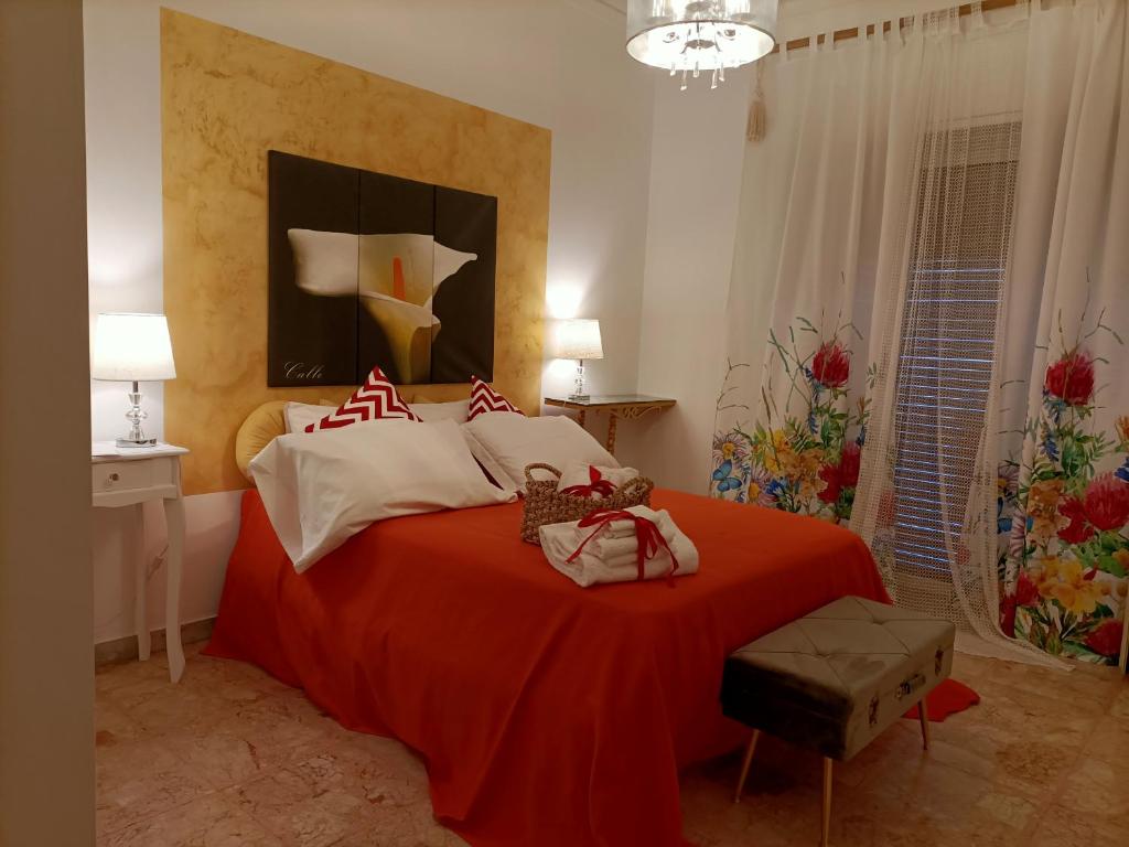 um quarto com uma cama grande e um cobertor vermelho em B&B Palazzo Armini em Rogliano