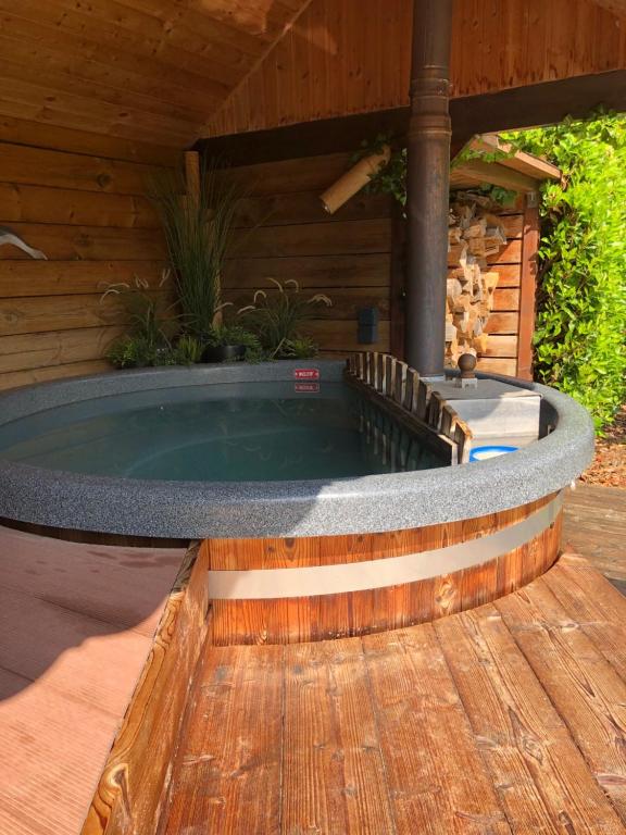 a hot tub in a deck with a wooden building at JustB in Riemst