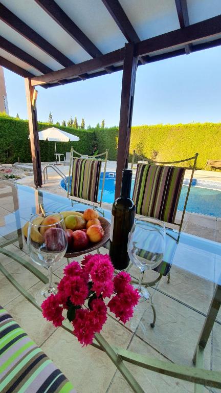 uma mesa com uma tigela de frutas e flores em Villa Victoria 400 meters to the beach em Pegeia ou Pegya