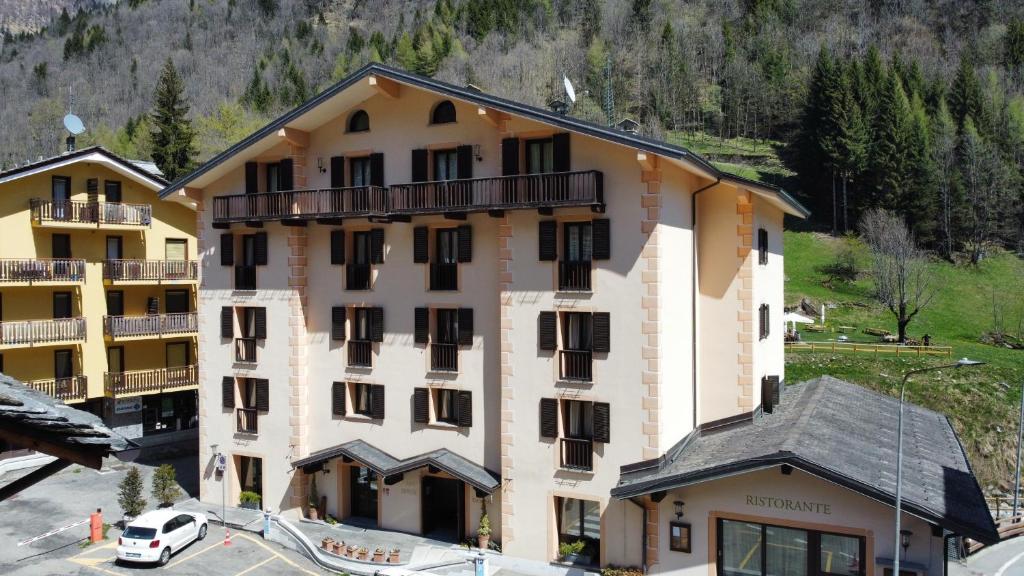 a large building with a car parked in front of it at Hotel Cristallo in Alagna Valsesia