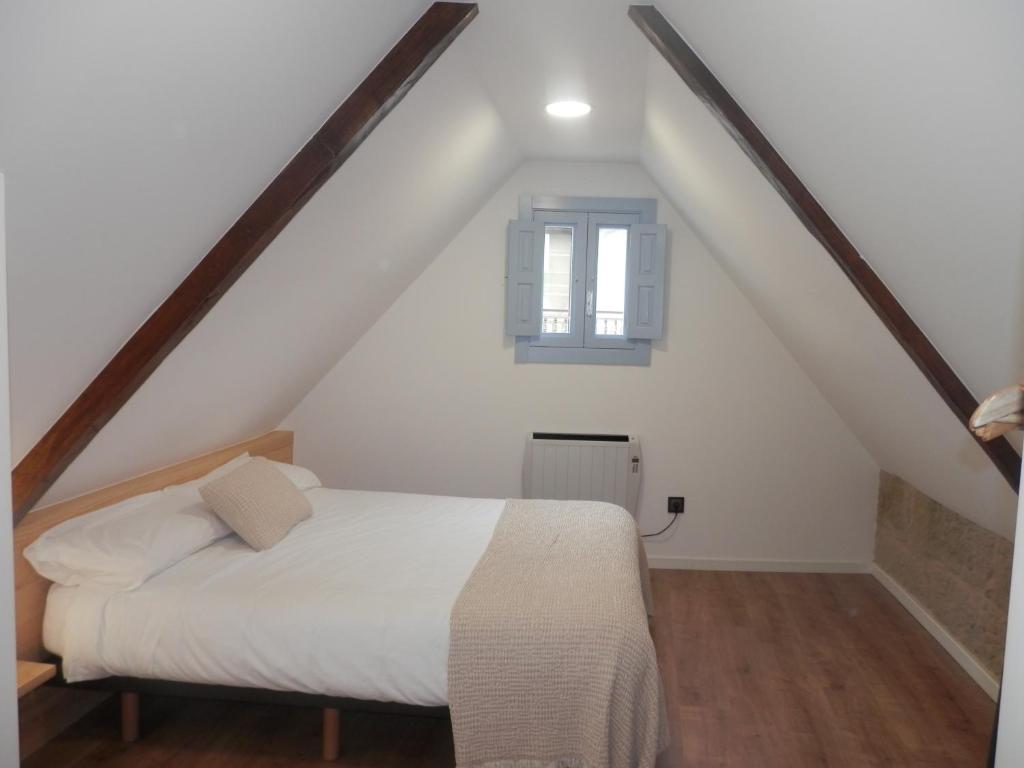 a bedroom with a white bed and a window at Lar Azul in Redondela