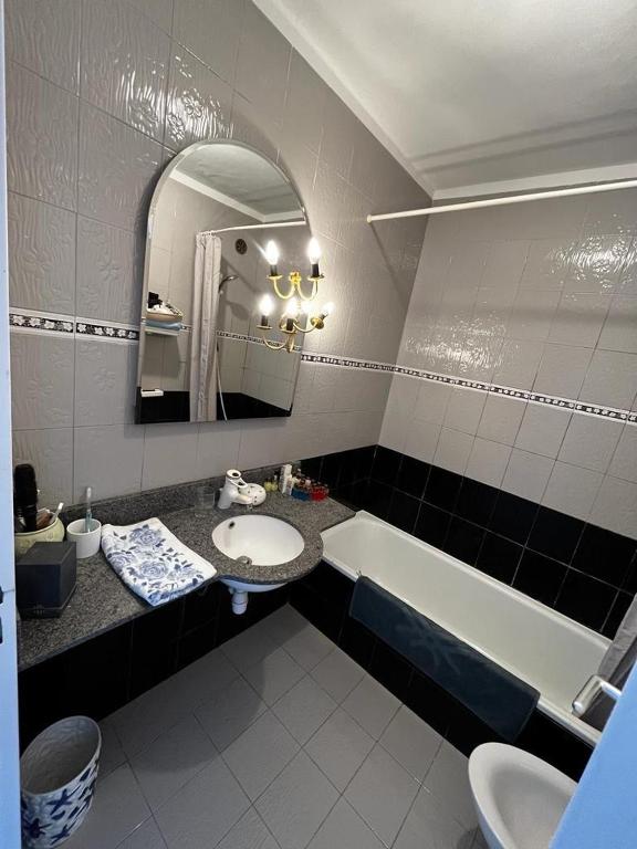 a bathroom with a sink and a tub and a mirror at Une terrasse sur Monaco logement 2 chambre in Beausoleil