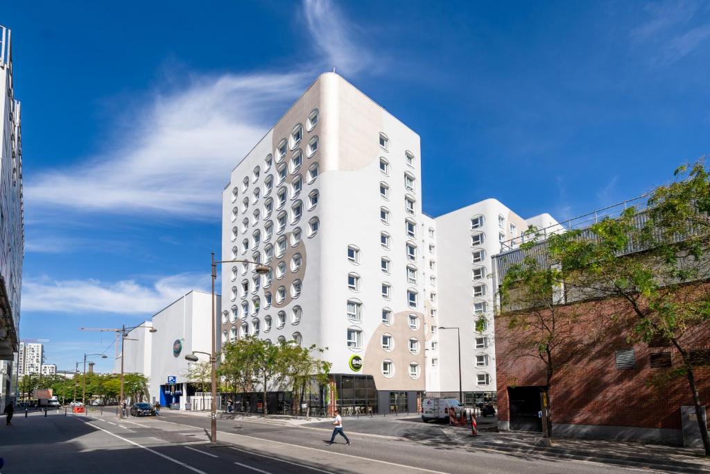 un grand bâtiment blanc dans une rue de la ville dans l'établissement B&B HOTEL Paris Ivry Quai de Seine, à Ivry-sur-Seine