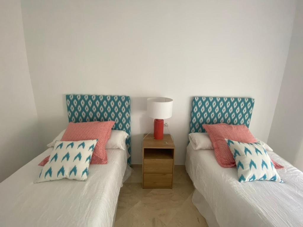 twee bedden naast elkaar in een kamer bij Precioso apartamento a pie de playa in Estepona