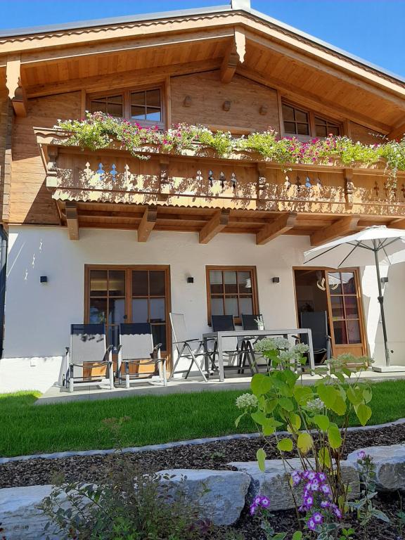 een huis met een balkon met planten erop bij Hochalmbahnen Chalets Rauris 1-08 WE2, Maislaufeldweg 1e OG in Rauris