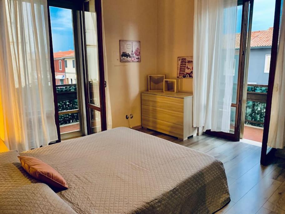 - une chambre avec un grand lit et de grandes fenêtres dans l'établissement Appartamento Santa Teresa, fiera/centro Verona, à Vérone