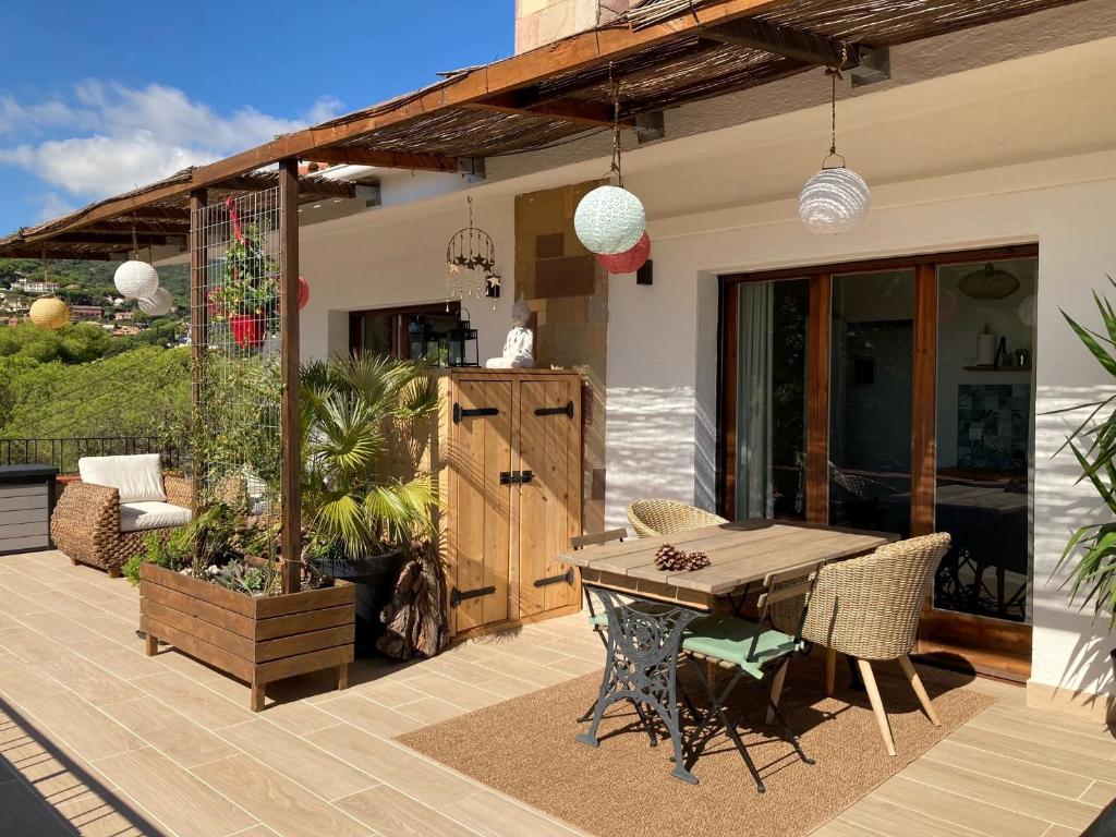 d'une terrasse avec une table et des chaises en bois. dans l'établissement Cozy place, big roof terrace & spectacular views., à Cabrils