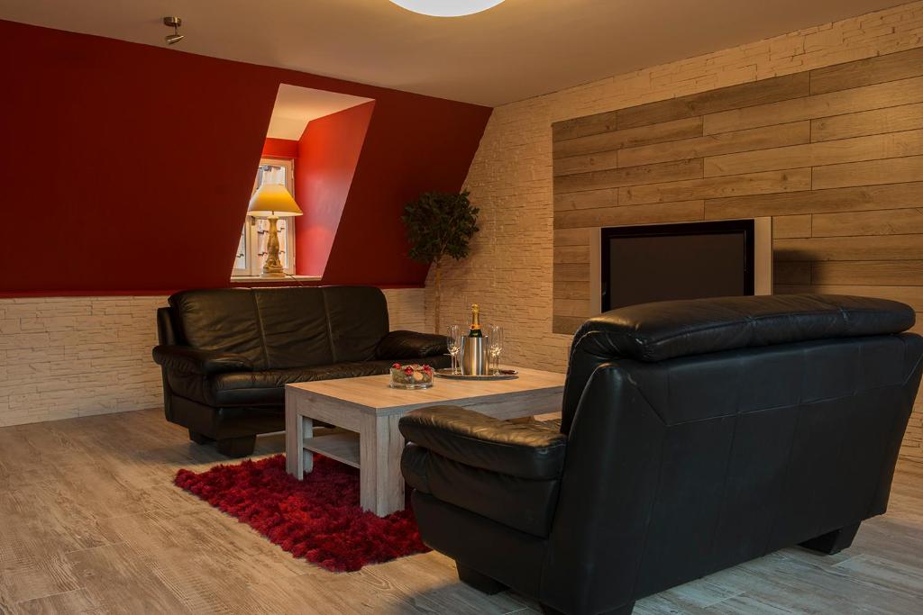 a living room with two leather chairs and a table at Apartment Alma in Quedlinburg