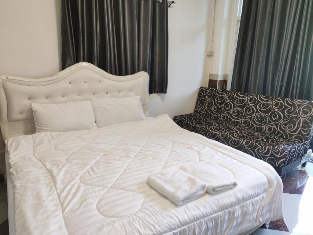 - un lit blanc avec 2 serviettes dans l'établissement SB Betong ห้องพักรายวัน, à Betong