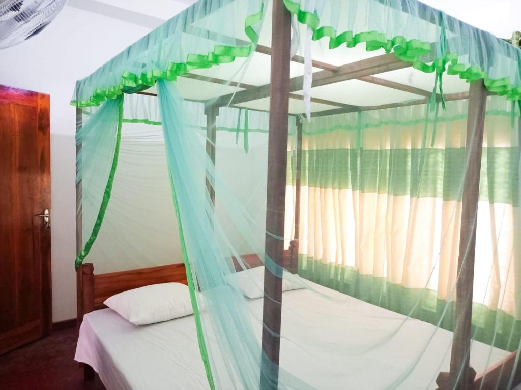 a bedroom with a four poster bed with a canopy at Sheen Holiday Resort in Tangalle