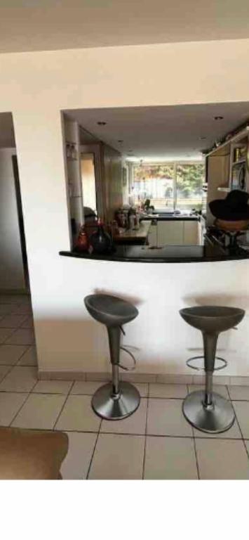 a kitchen with two stools in front of a counter at Une terrasse sur Monaco logement 2 chambre in Beausoleil