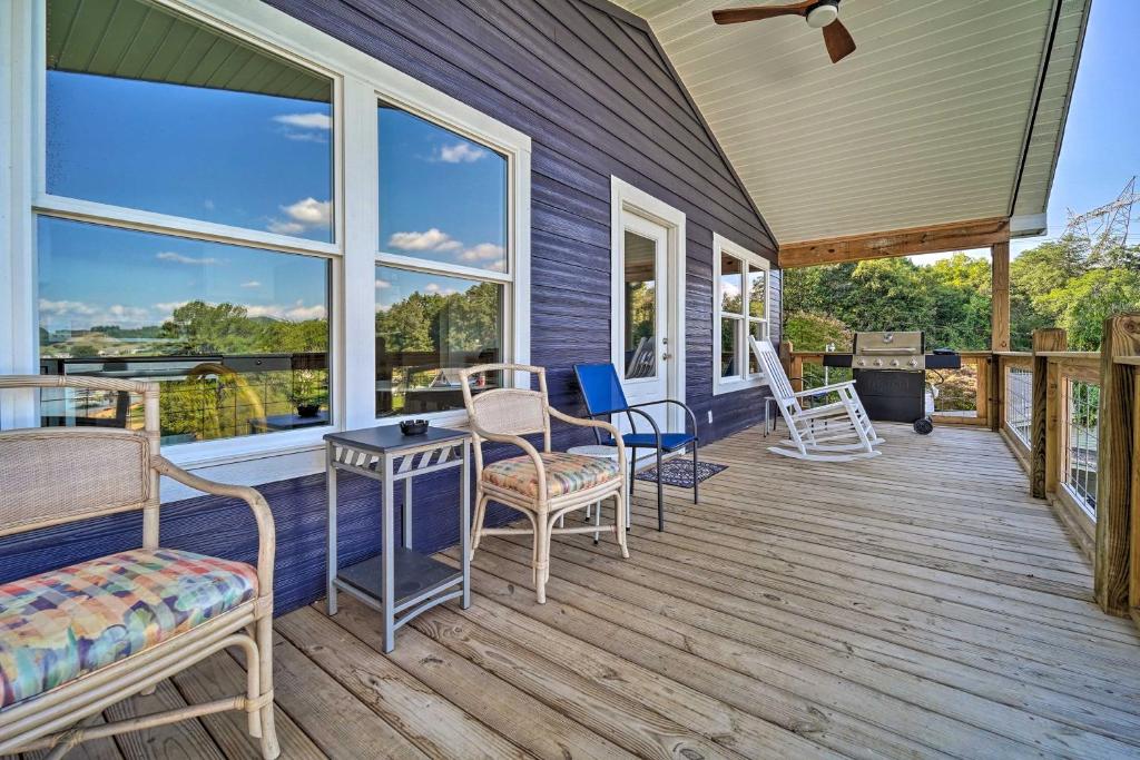 - une terrasse couverte avec des chaises, des tables et des fenêtres dans l'établissement Bean Station Cottage Unobstructed Lake Views, à Bean Station