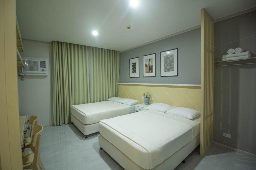 um quarto de hotel com duas camas num quarto em Twin Hearts Residences 1 em Roxas City