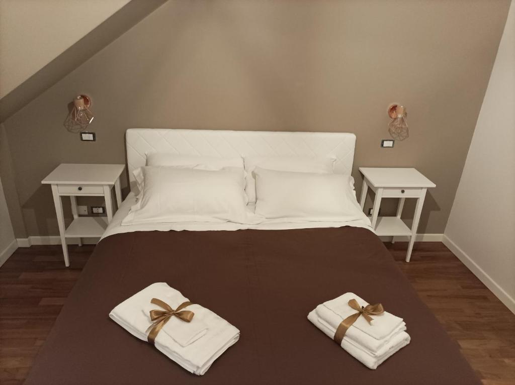 Una cama con toallas blancas y arcos. en Dimora Italia, en Campobasso