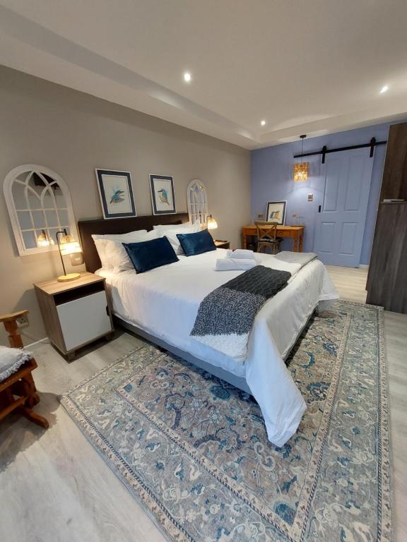 a bedroom with a large bed and a rug at Coral Tree Boutique Guesthouse in East London