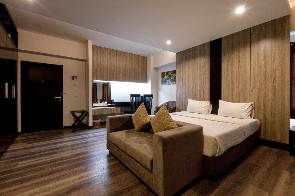 a hotel room with a bed and a couch at Grand Marina Residence Hotel in Ban Laem Chabang