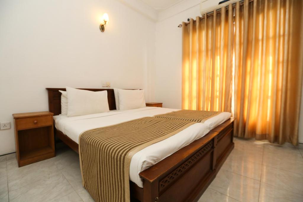 a bedroom with a large bed with a large window at The Delight Residence in Kandy