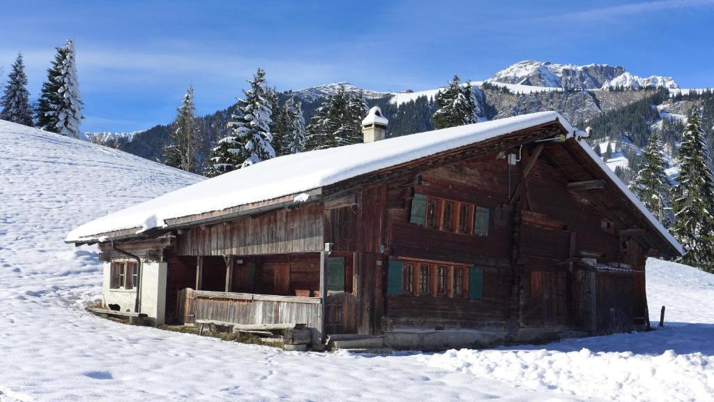 Cabaña de madera con nieve encima en Hami, en Adelboden