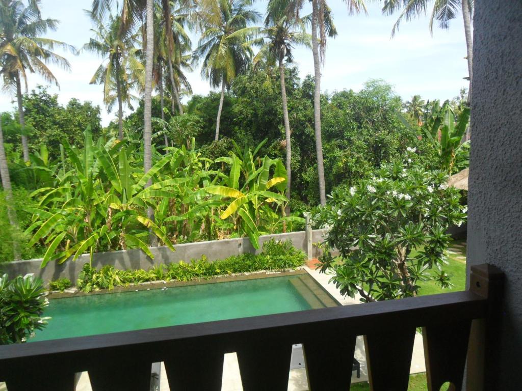 a view of a swimming pool from a balcony at Ju'Blu Hotel in Lovina