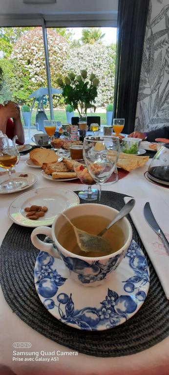 una mesa con un tazón de sopa y vasos. en Chambres d'hôtes Les Chênes, en Acigné