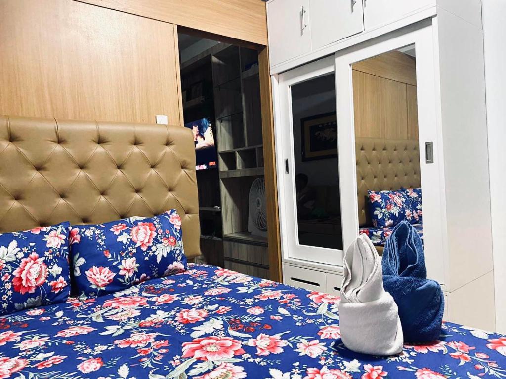 a bedroom with a bed with a blue floral bedspread at Sea Residences - Property Val Alano 0995-448-8872 in Manila