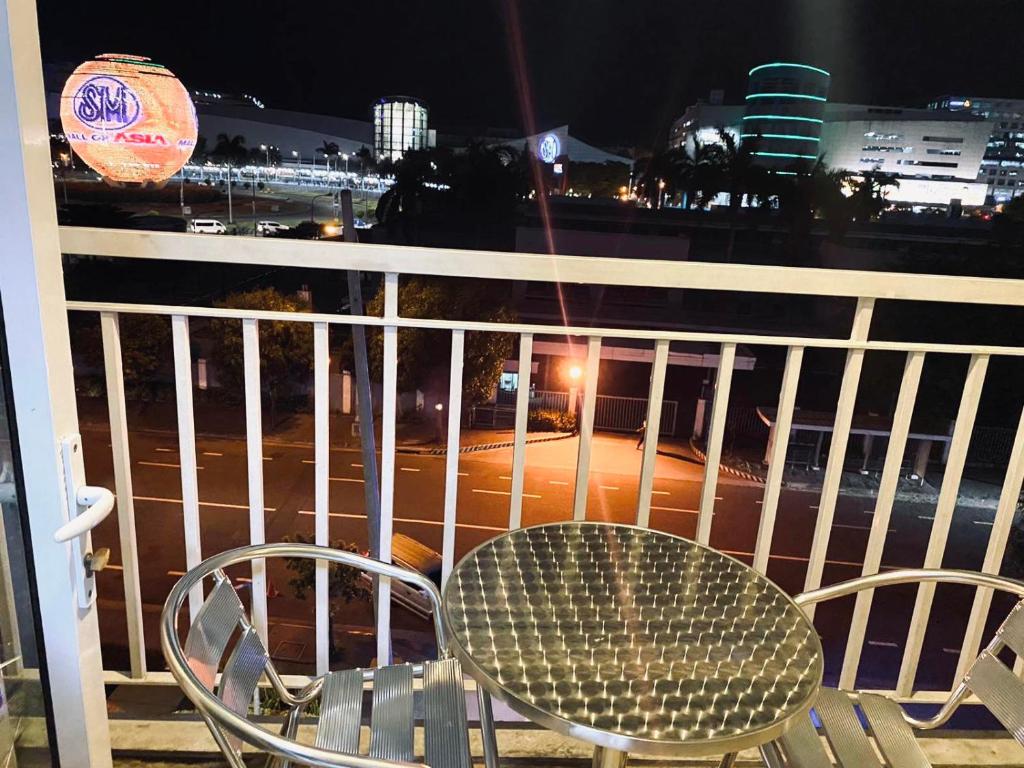 a table and chairs on a balcony at night at Sea Residences - Property Val Alano 0995-448-8872 in Manila