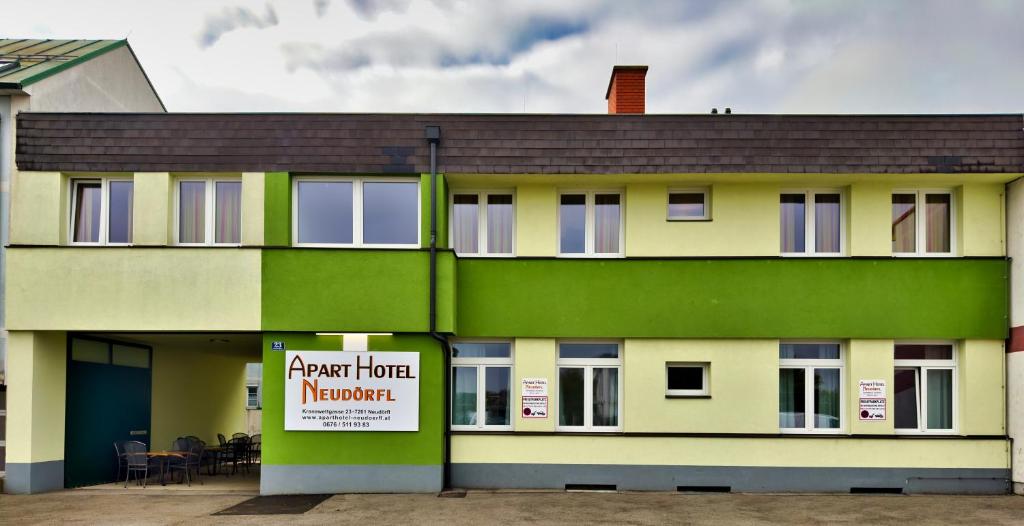 a green and white building with a sign on it at Aparthotel Neudörfl in Neudörfl