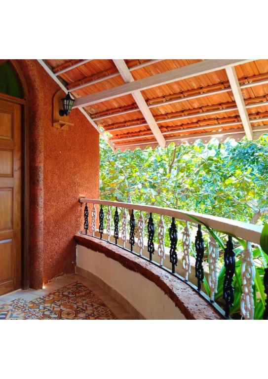 a balcony of a house with a wooden railing at villa goa in Cola