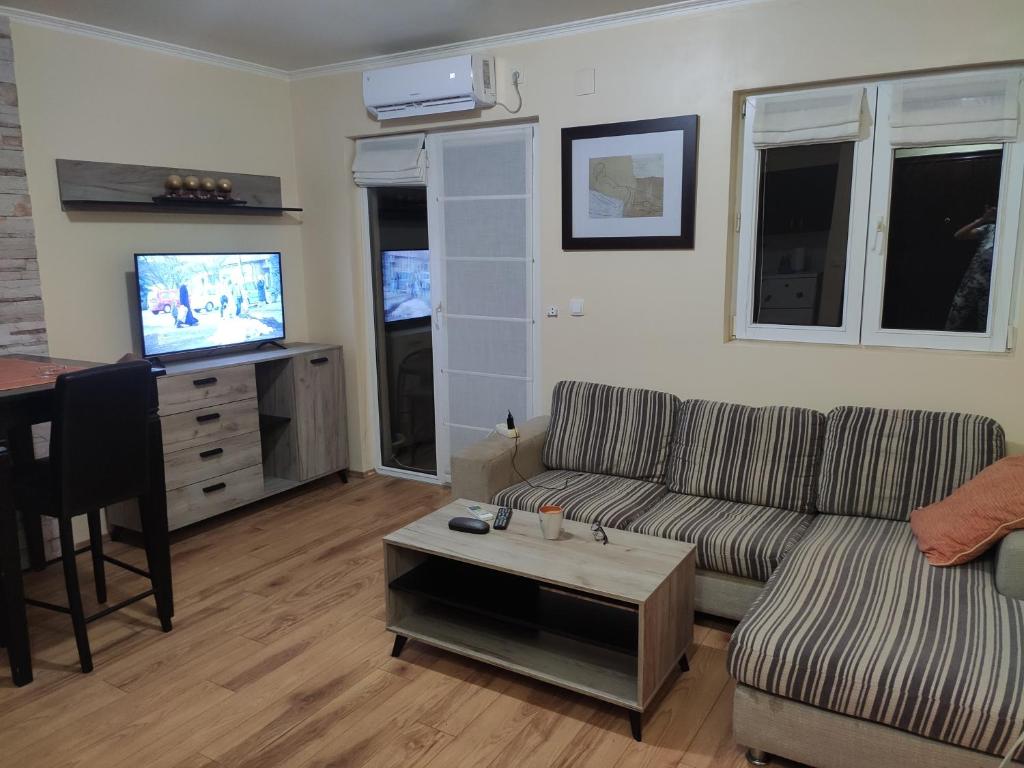 een woonkamer met een bank, een tafel en een tv bij Zone Knezevac in Belgrado