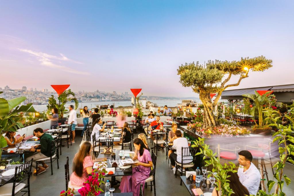 pessoas sentadas em mesas no telhado de um restaurante em Seres Hotel Old City em Istambul