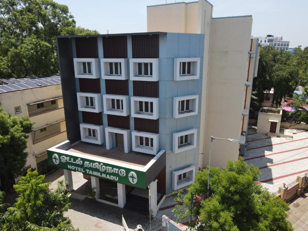 un edificio alto con un cartel delante en Hotel TamilNadu -Trichy en Tiruchchirāppalli