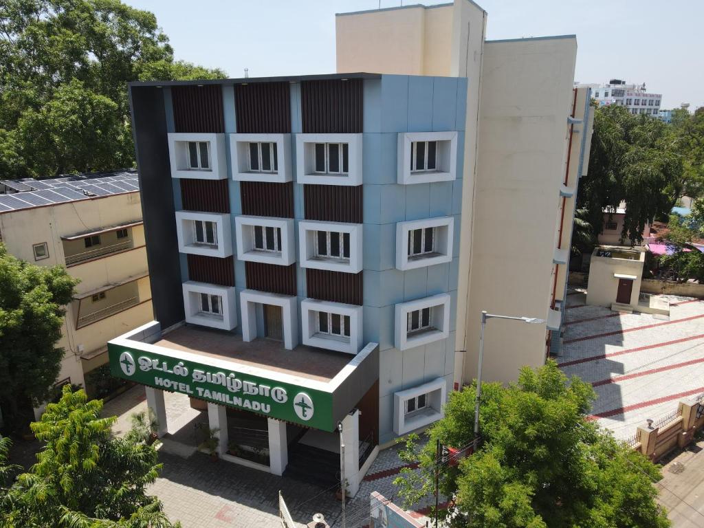 a tall building with a sign in front of it at Hotel Tamilnadu Trichy in Tiruchirappalli