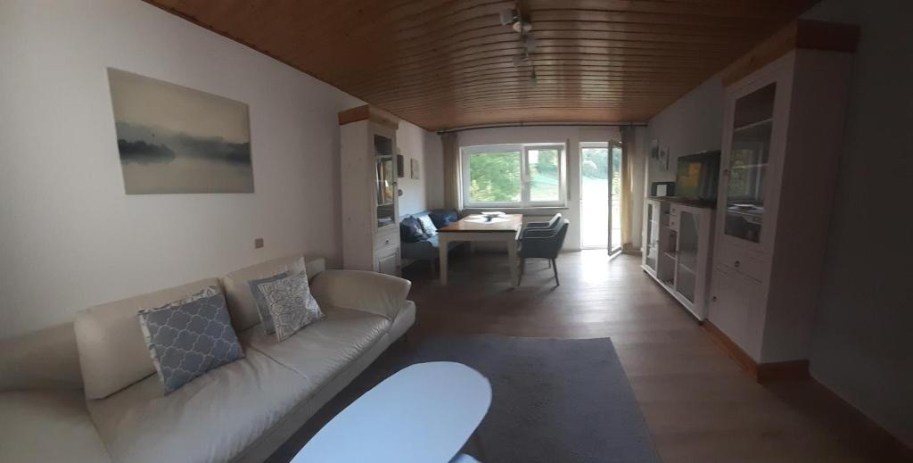 ein Wohnzimmer mit Couch und Tisch in der Unterkunft Ferienwohnung am Bach in Mörlenbach