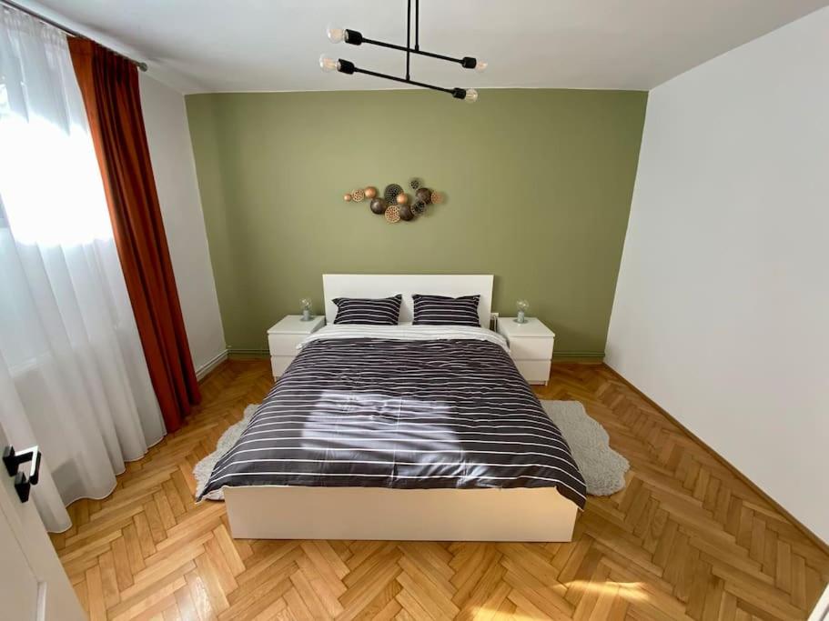 Schlafzimmer mit einem Bett mit einer schwarzen und weißen Bettdecke in der Unterkunft Deluxe Apartment #CasaMihai Free Parking in Braşov