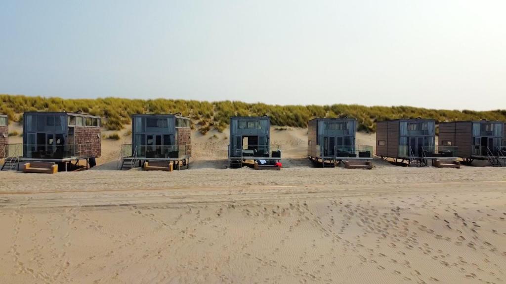 a row of beach huts sitting in the sand at Slaapzand in Domburg