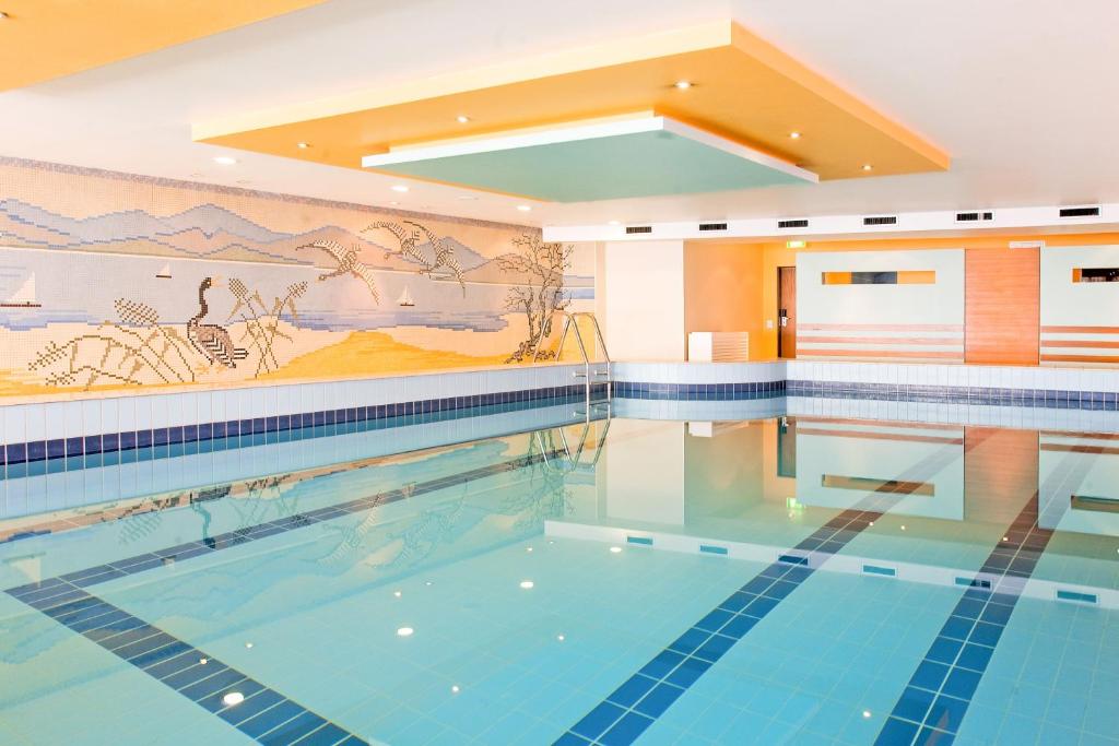 a swimming pool with a mural on the wall at Hotel Lyskirchen in Cologne