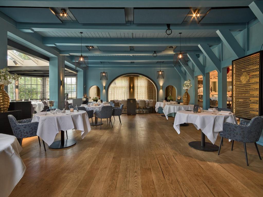 een eetkamer met witte tafels en stoelen bij De Nederlanden, Restaurant & Boutique Hotel in Vreeland