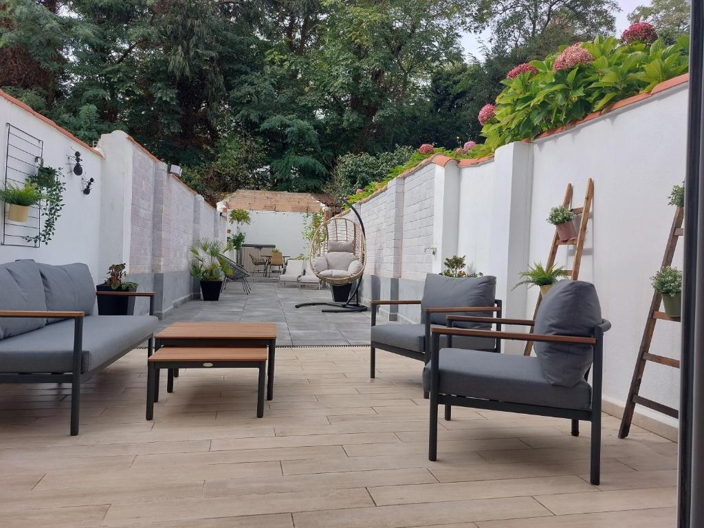 un patio con sillas, mesa y plantas en El Patio de Rivero con garaje, Avilés en Avilés