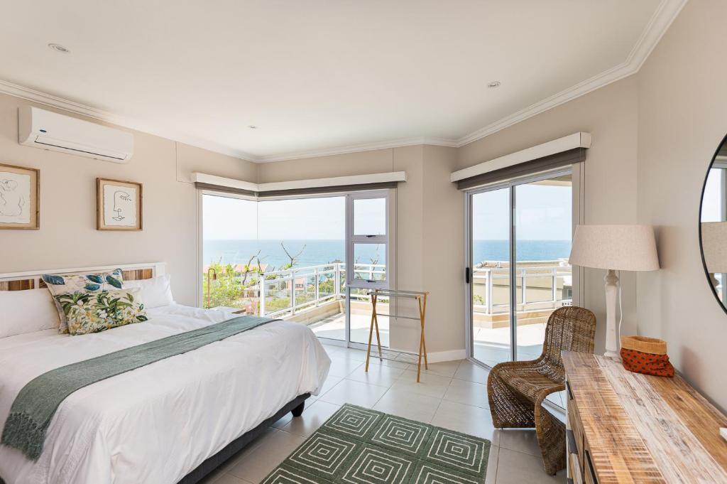 a bedroom with a bed and a view of the ocean at Les Dauphine 13 in Ballito